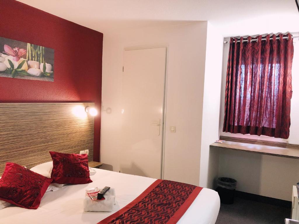 ノイエル・ゴドーにあるFasthotel Lens Noyelles Godaultの赤い壁のベッドが備わるホテルルームです。