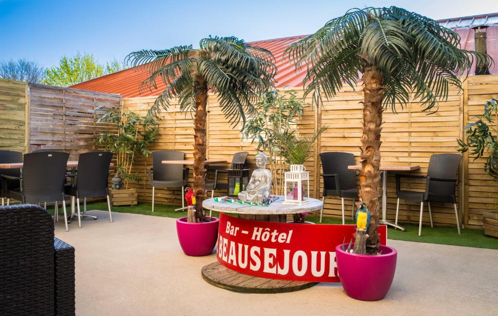 a table with palm trees and a sign that reads hotel malibuatown at hotel le beauséjour in Langogne