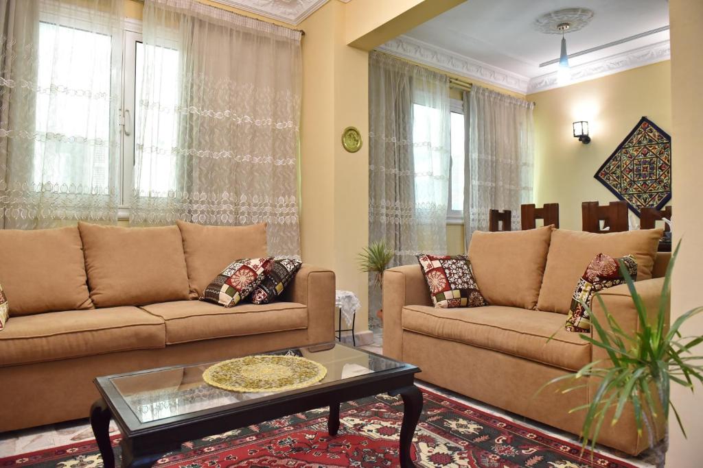 a living room with two couches and a coffee table at Two-Bedroom Apartment at Mohamed Farid Street in Cairo