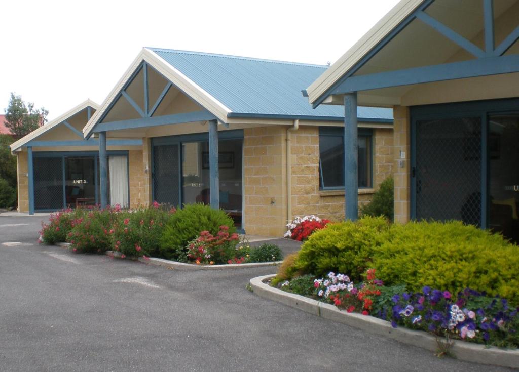 a large building with a flower garden in front of it at Summers Rest Units in Port Campbell