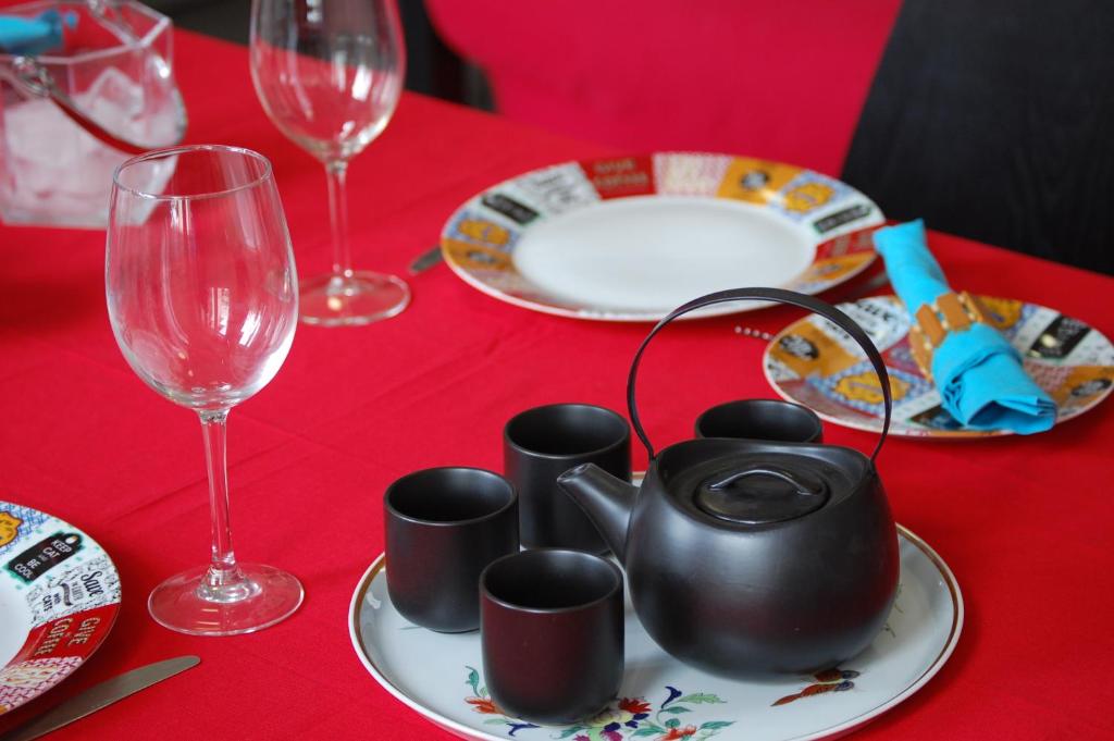フンシャルにあるCapuchinhas Apartmentの赤いテーブル(赤いテーブルクロス、皿、メガネ付)