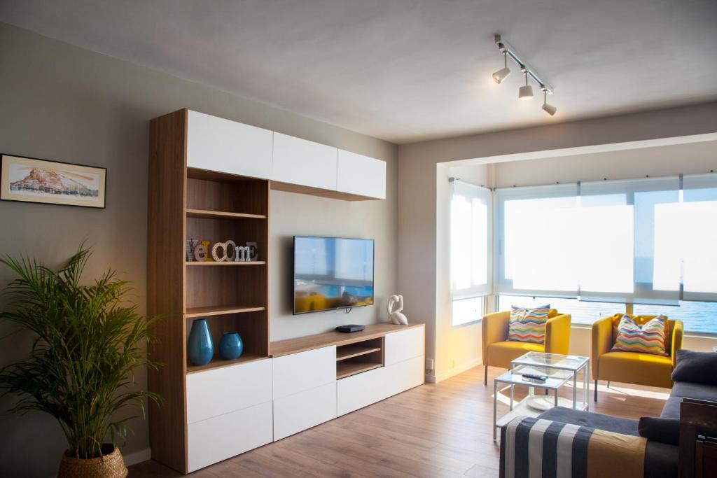 uma sala de estar com um sofá e uma televisão em Apartamento con Vistas al MAR em Alicante