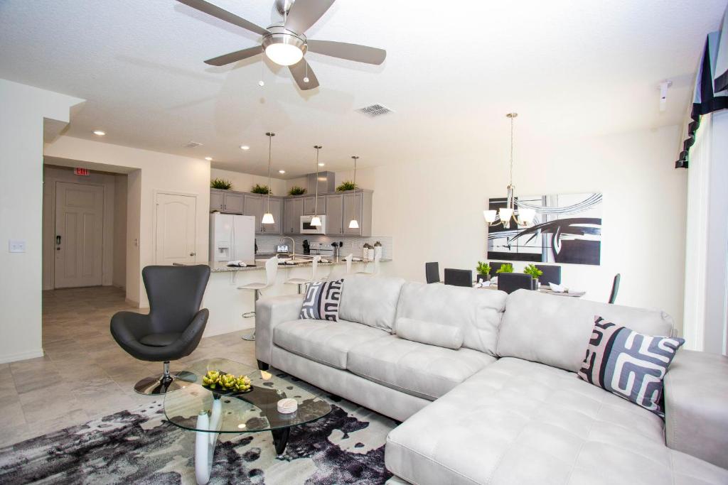 sala de estar con sofá blanco y ventilador de techo en Four Bedroom Close to Disney 5149A, en Kissimmee