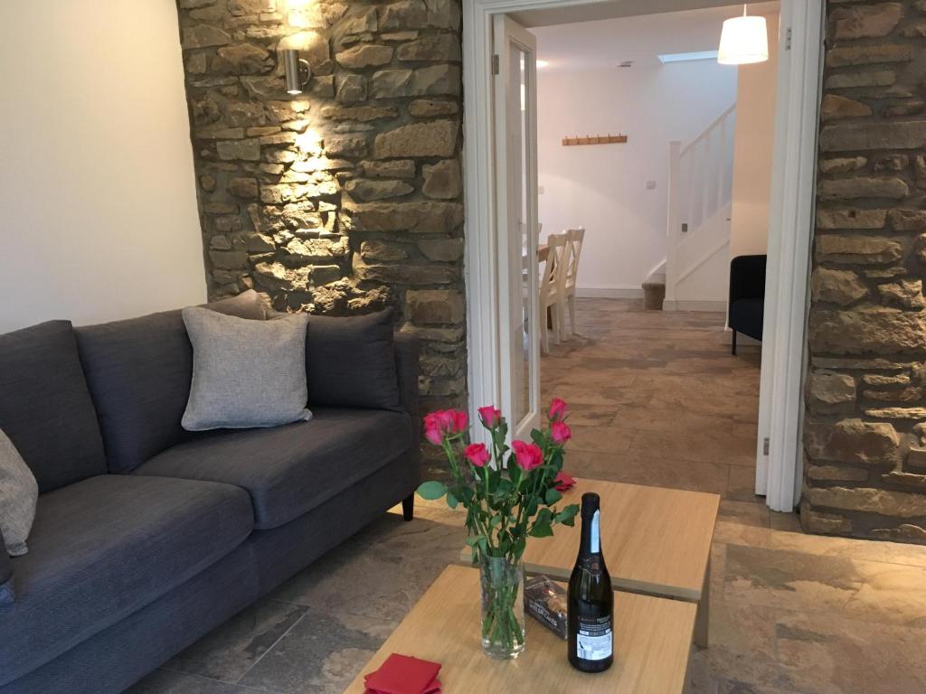 a living room with a couch and a table with flowers at Ty Glo Cottage in Brecon