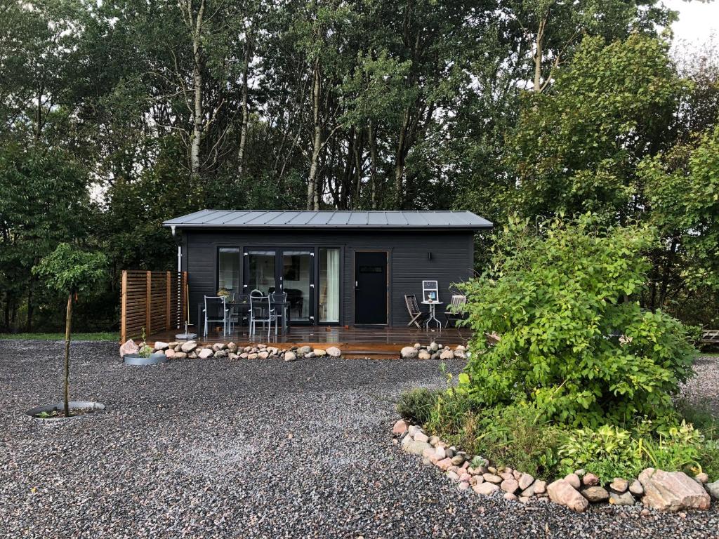 a tiny house in the woods with a patio at Compact living home, DOWNSIZING PROJECT in Falkenberg