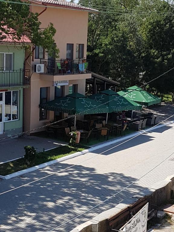 a patio with tables and umbrellas in front of a building at Casa Amiral in Sulina