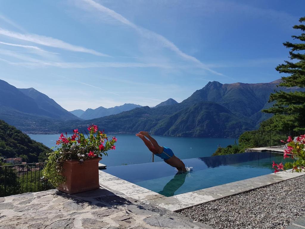 een zwembad met uitzicht op een meer en de bergen bij Villa Silvi piscina sauna e hot tub in Perledo