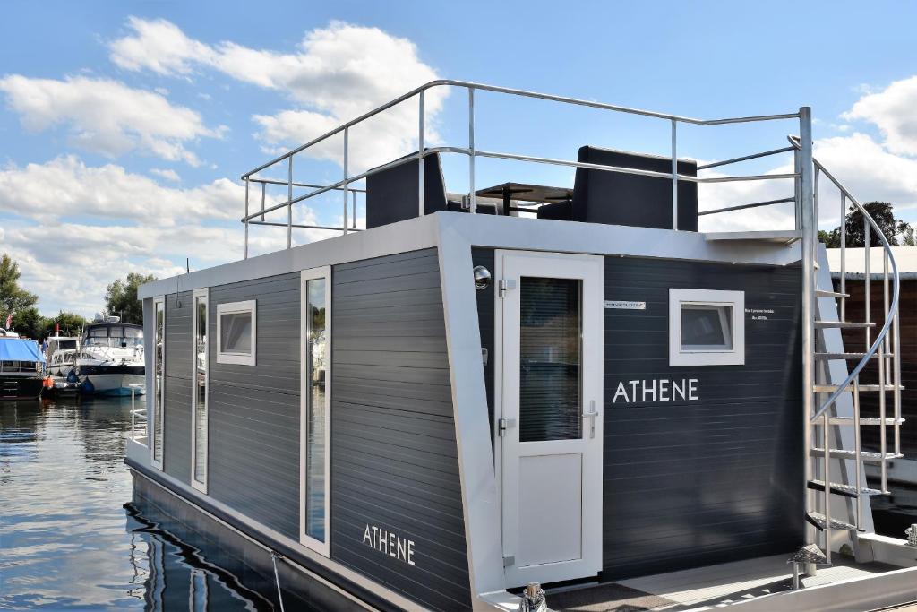 a small boat is docked in the water at Cosy floating boatlodge Athene in Maastricht
