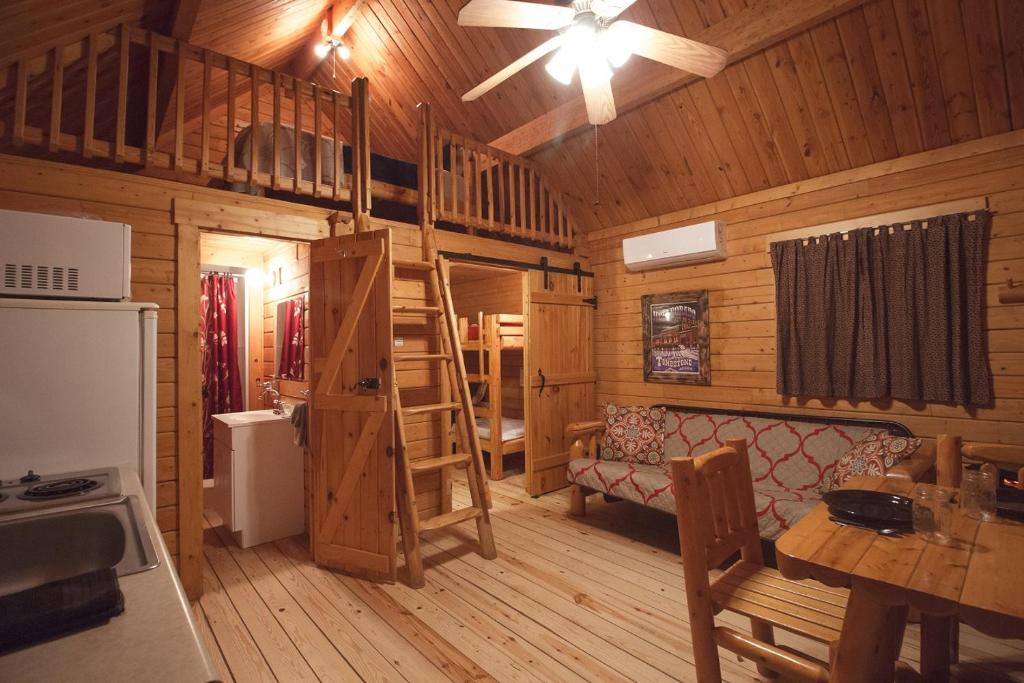 a log cabin with a kitchen and a living room at Katie's Cozy Cabins in Tombstone