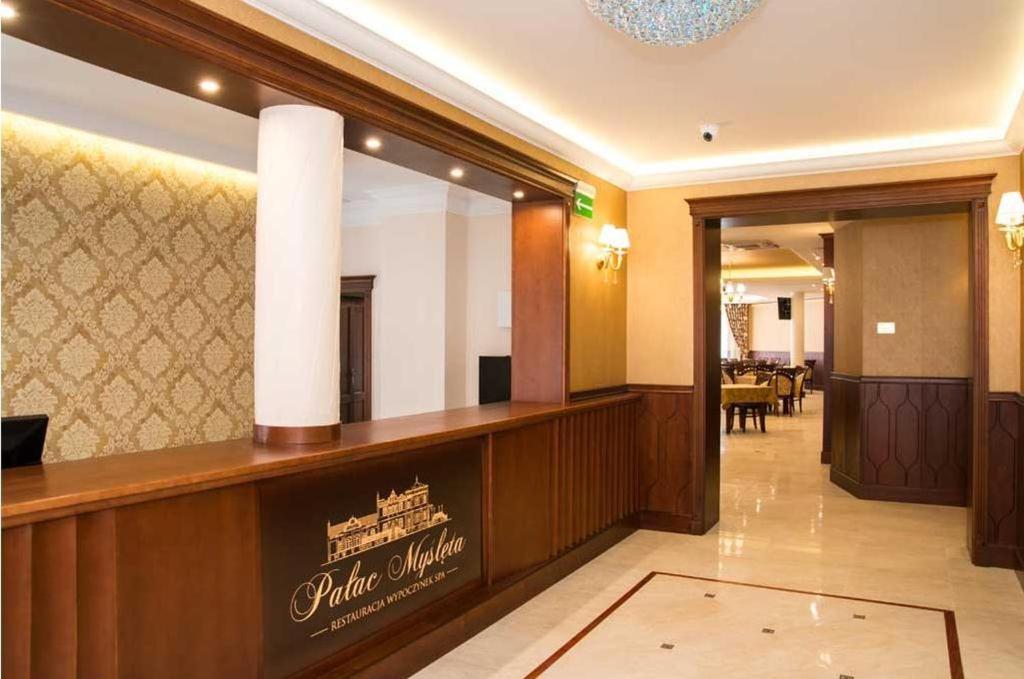 a hotel lobby with a mirror and a waiting room at Pałac Myślęta in Uzdowo