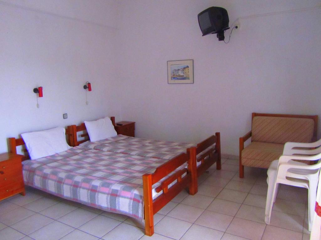 a bedroom with a bed and a chair at Villa Sofia in Limenaria