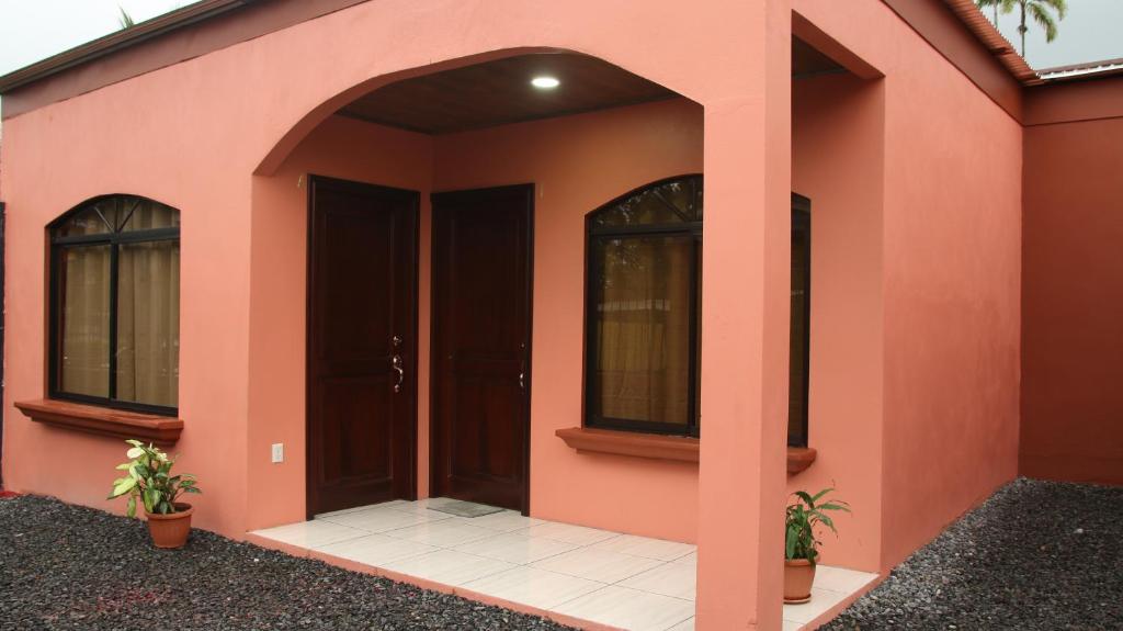 Casa rosa con puerta y ventanas en Arenal Red, en Fortuna