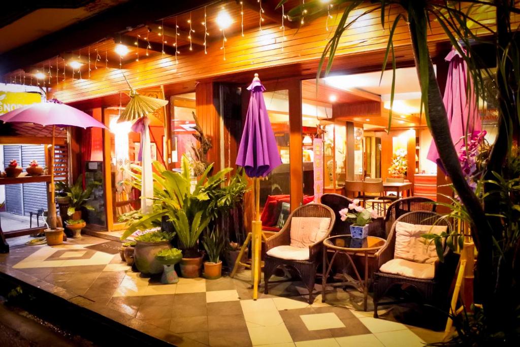 een lobby met stoelen, parasols en planten bij The North Hotel in Chiang Rai