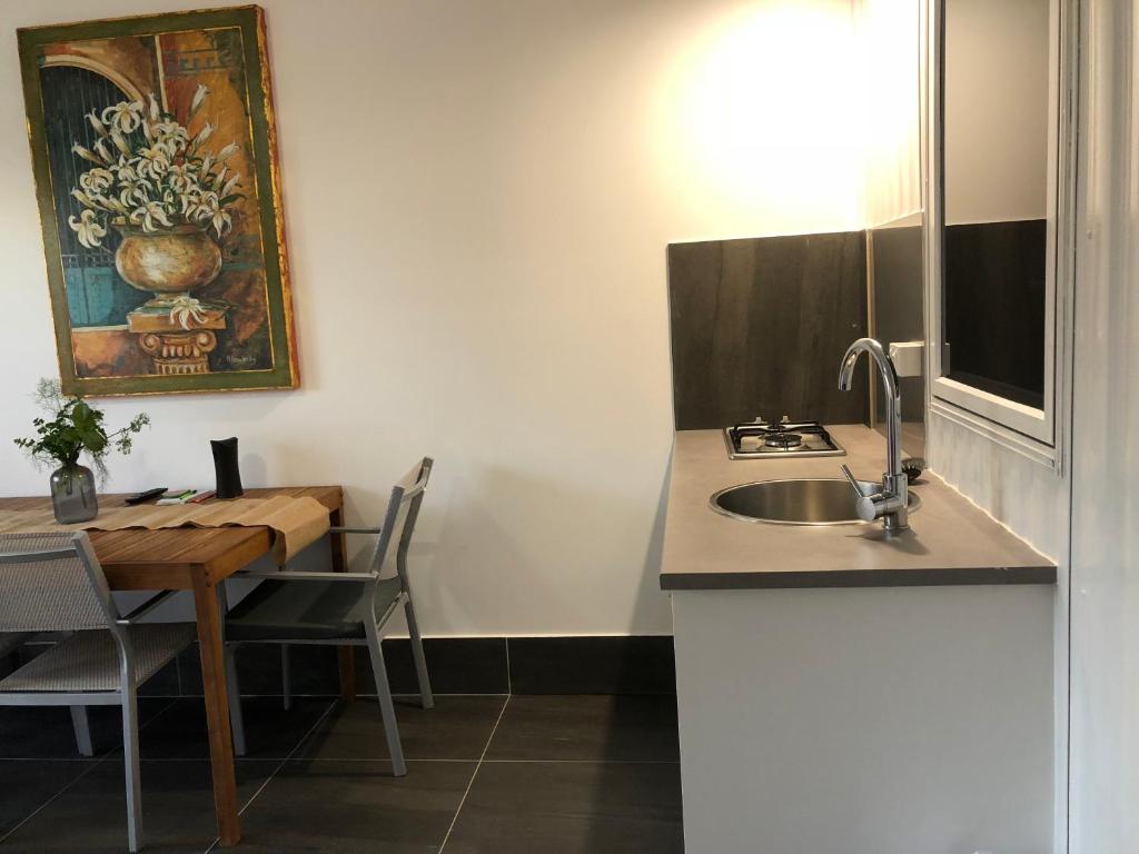 uma cozinha com um lavatório e uma mesa de jantar em Coonawarra Ensuite Unit A em Coonawarra