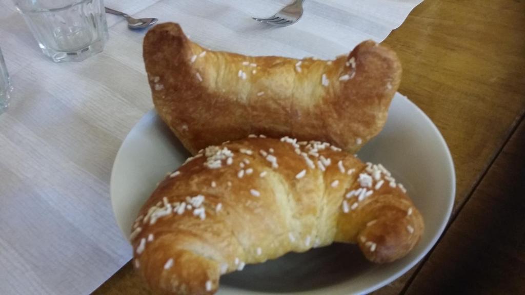 twee croissants op een wit bord op een tafel bij Bed & Breakfast 1906 in San Martino In Strada