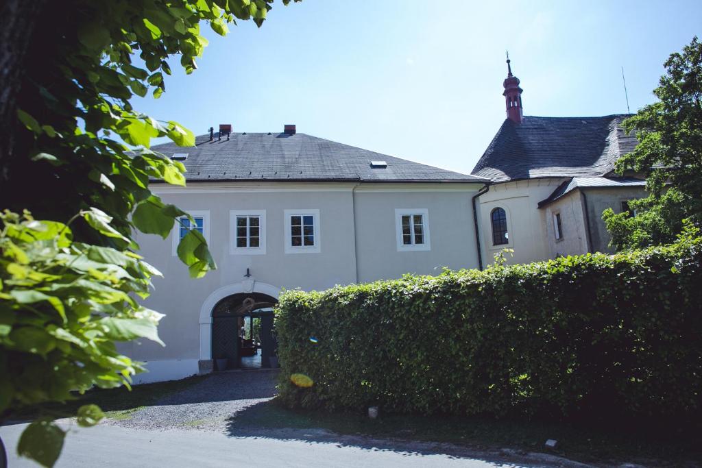 una casa blanca con una puerta y un seto en Baroque mansion Czech Paradise 1750 A. D. en Malá Skála