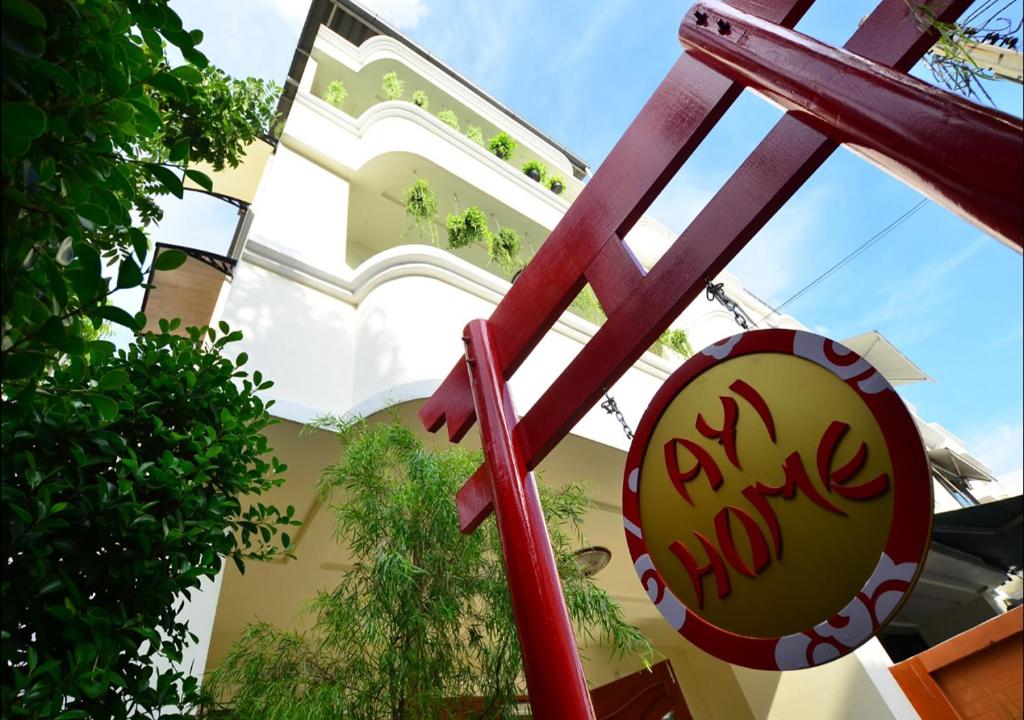 a red chair in front of a building at Ayi Home in Bangkok