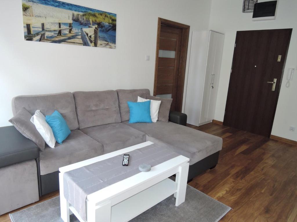 ein Wohnzimmer mit einem Sofa und einem Couchtisch in der Unterkunft Apartament Morena in Świnoujście