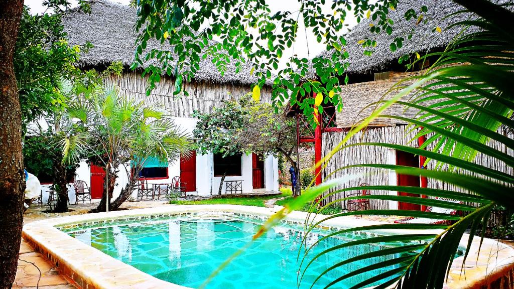 a swimming pool in the yard of a house at Diani Hostel in Diani Beach