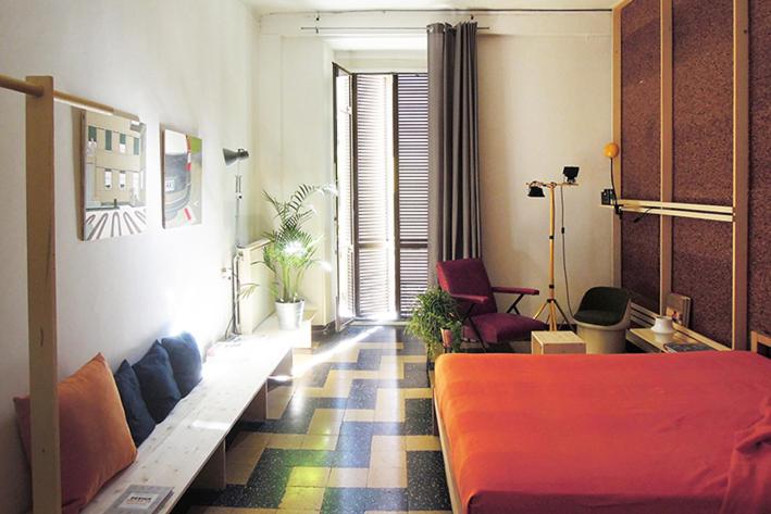 ミラノにあるDesign Double View Flatのベッド、ソファ、椅子が備わる客室です。