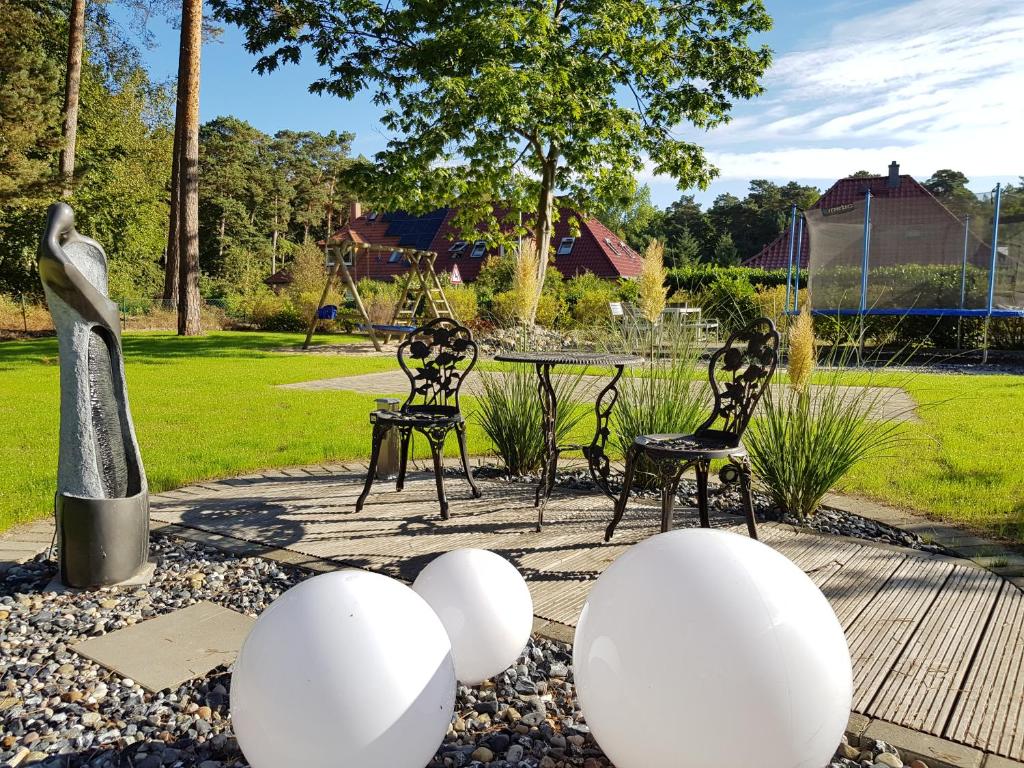 un jardín con 2 sillas y huevos blancos en el suelo en Zur Alten Post Prora en Binz