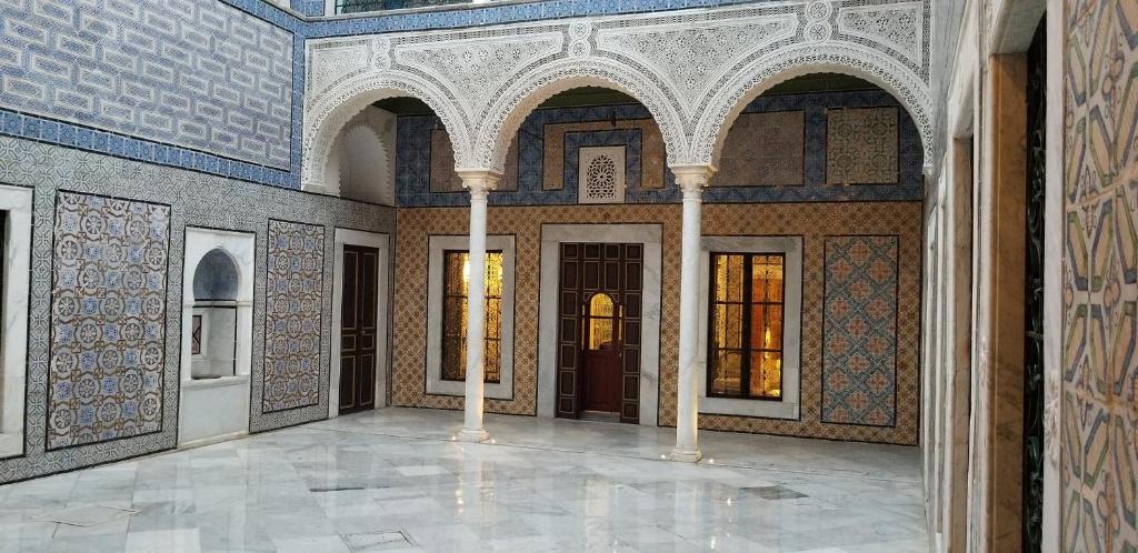 Palais Bayram في تونس: غرفة فارغة مع اعمدة وسقف في مبنى