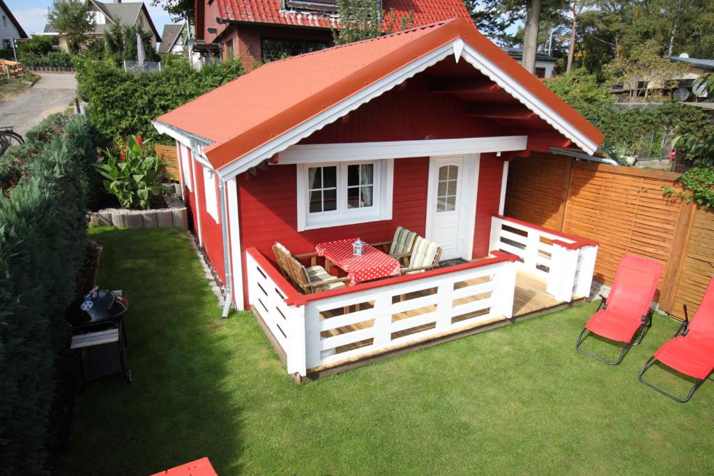 a red shed with a red roof on a lawn at Blockbohlenhaus Plau am See in Plau am See