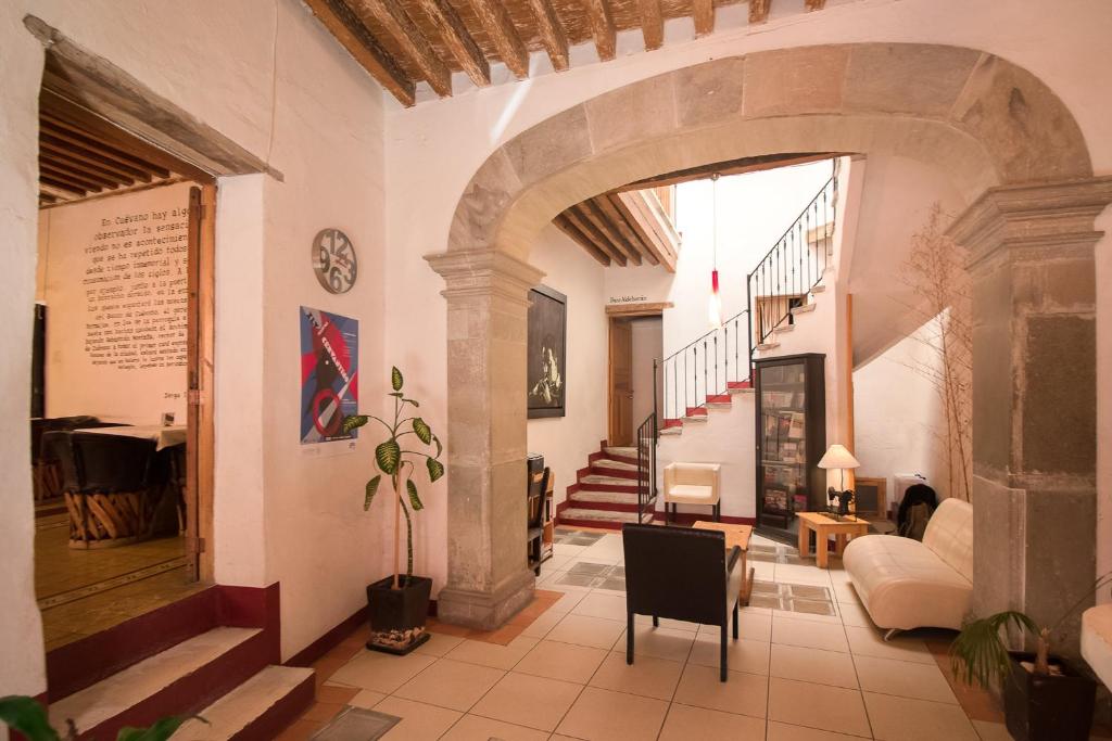 a living room with an archway and a staircase at Hotel Meson Cuevano in Guanajuato