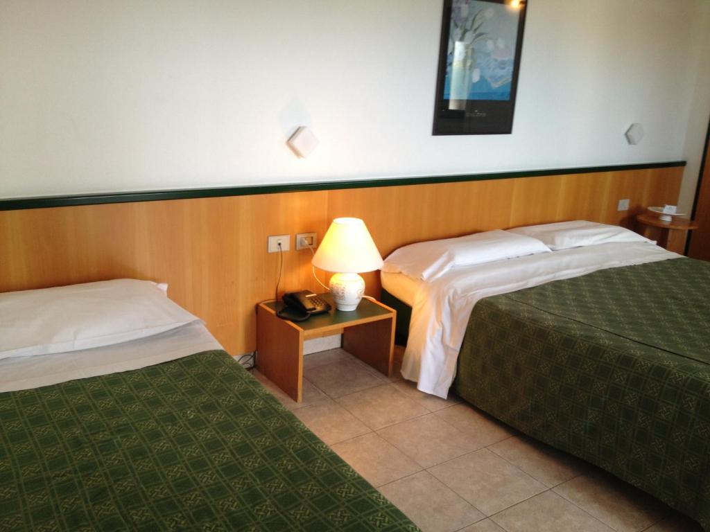 Postel nebo postele na pokoji v ubytování Hotel Ambrosio La Corte