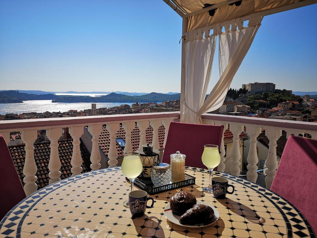 una mesa con copas de vino y vistas al océano en Apartment Lorena, en Šibenik