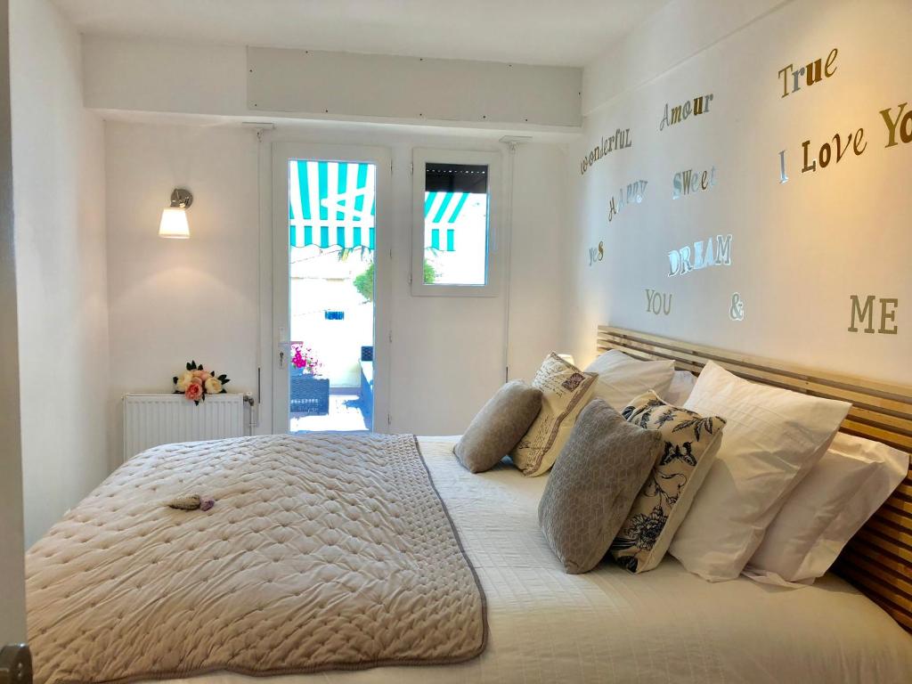 a bedroom with a large bed with pillows at Appartement Cosy Calme Central-Terrasse Proche Palais in Cannes
