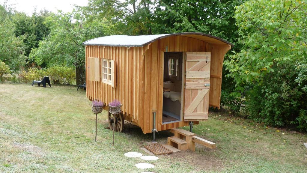 a wooden shed with a cat in a yard at Schäferwagen "Hirtenstern" in Hilders