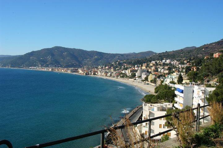 een uitzicht op een strand met gebouwen en de oceaan bij appartamento vicino al mare Alassio in Alassio