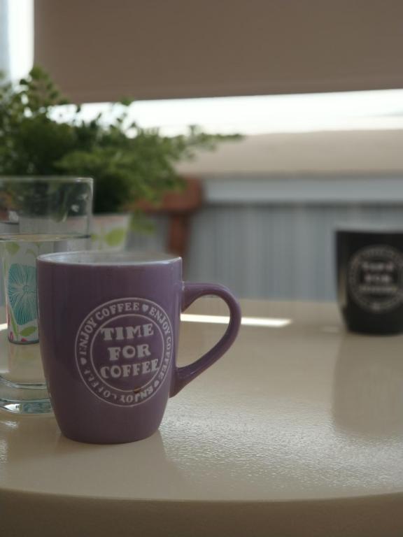 a purple coffee cup sitting on a table at Elena Apartmen in Larnaka