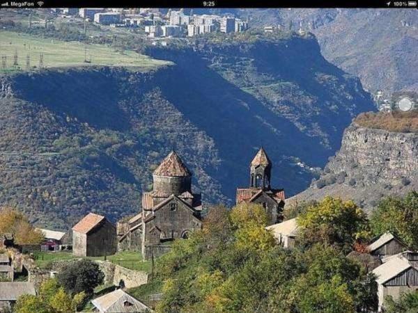 a group of buildings on a hill with a body of water at B&B Edem in Haghpat