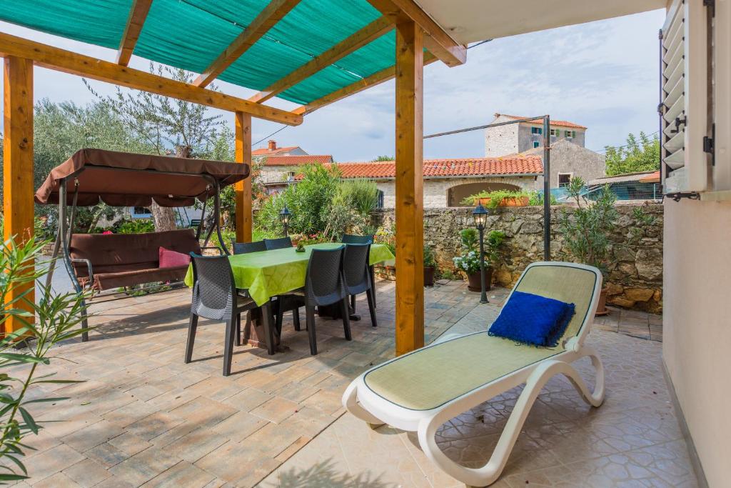 a patio with a table and chairs and a pergola at Apartment Macan in Bale