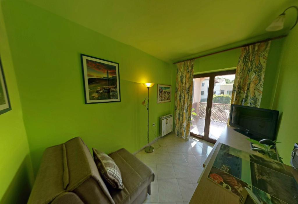 een groene woonkamer met een bank en een televisie bij Anica Apartment in Banjole