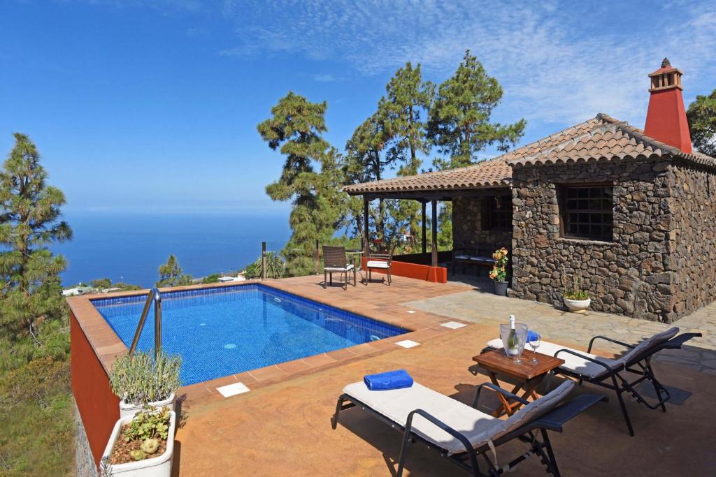 a villa with a swimming pool and a house at Casa Antonia in Tijarafe