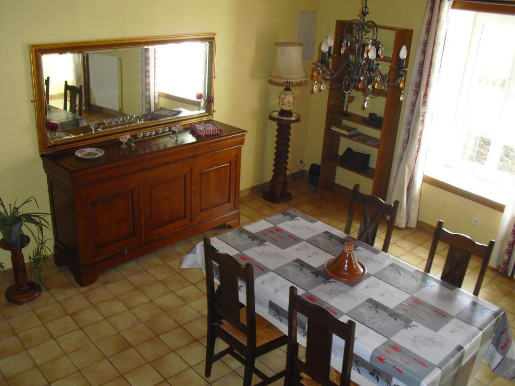 a dining room with a table and a mirror at Vacances à Réthoville in Réthôville