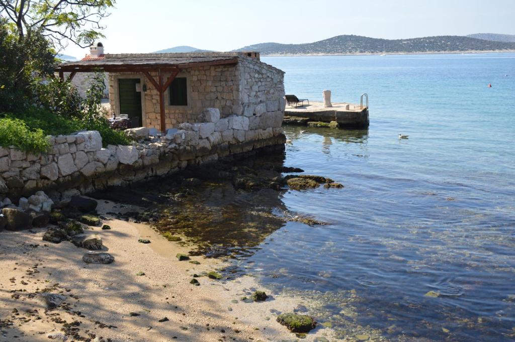 un edificio en la orilla de un cuerpo de agua en studio apartman Kata, en Prvić Šepurine