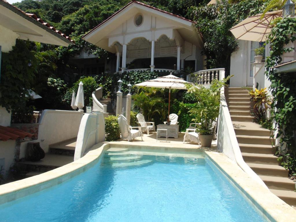 a swimming pool in front of a house at Villa Caprichosa in Taboga