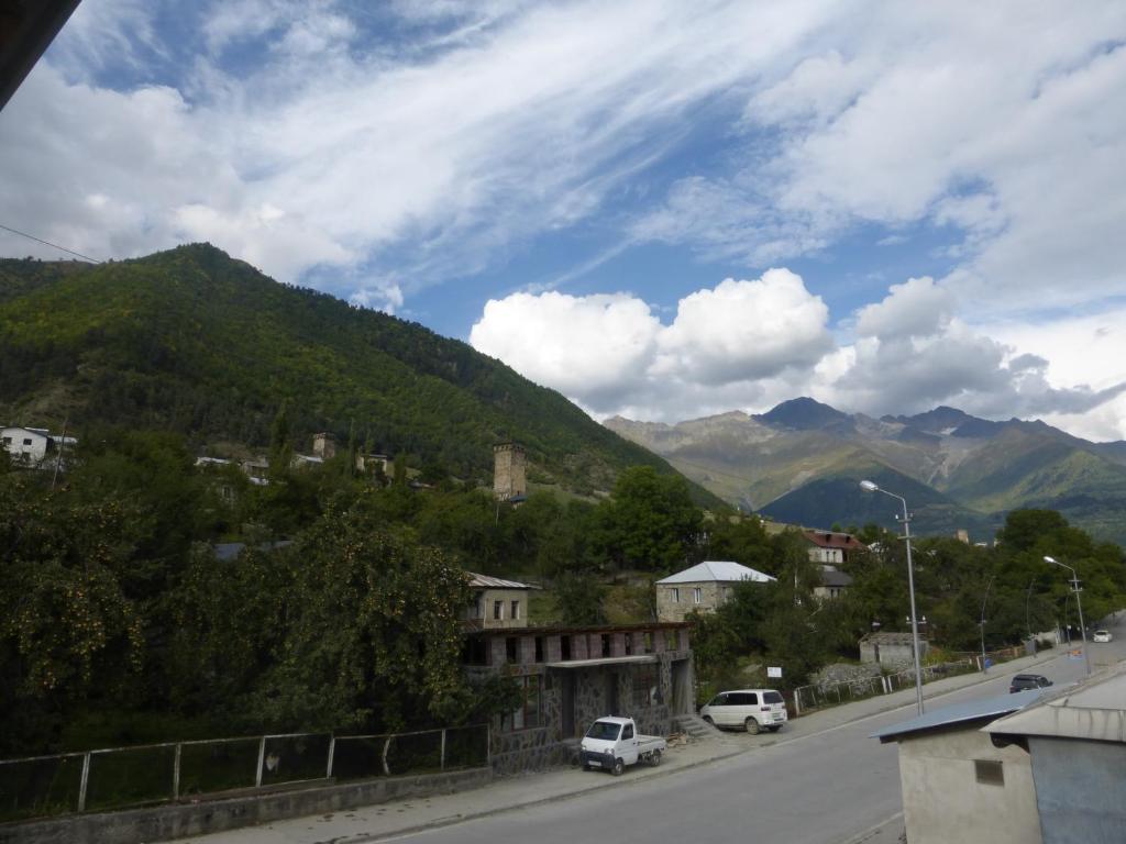 a street in a town with mountains in the background at Guesthouse Mabu - 4 Newly Built Rooms in the Heart of Mestia in Mestia