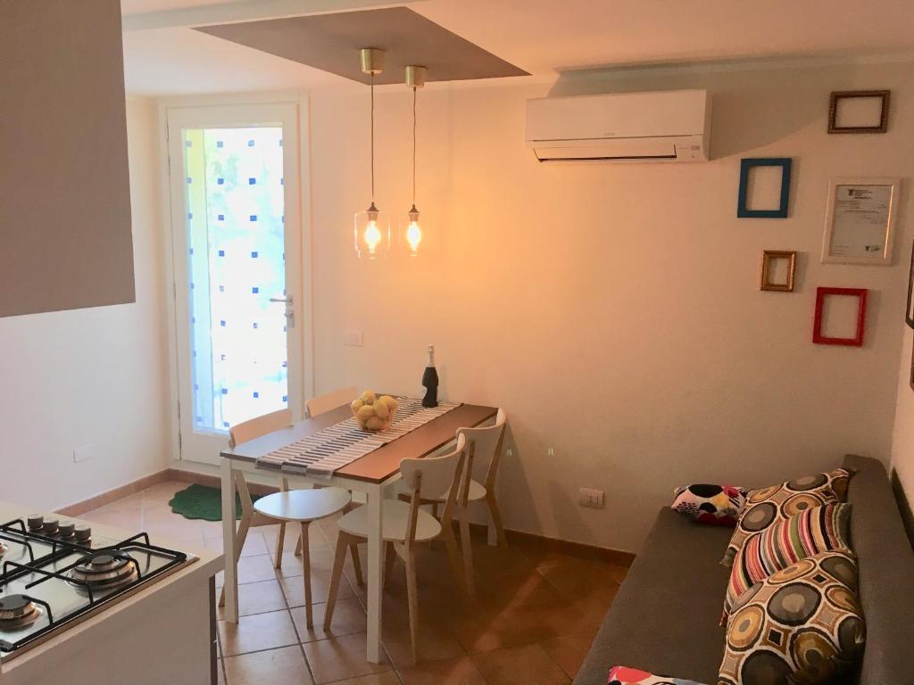 a kitchen and dining room with a table and a couch at Villa Benaco in Pozzolengo