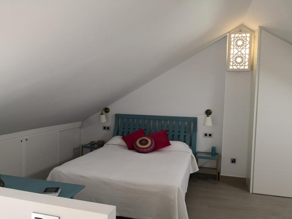 a bedroom with a white bed with red pillows on it at Apartamentos en Paseo Maritimo in El Rompido