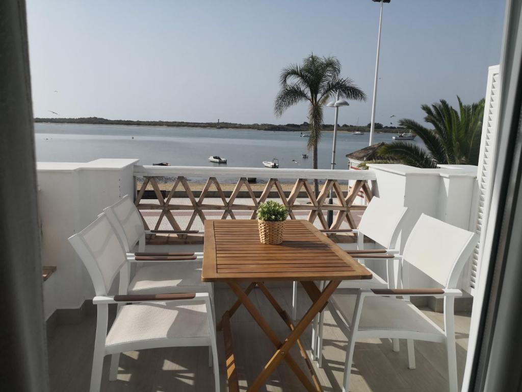 a table and chairs on a balcony with a view of the ocean at Apartamentos en Paseo Maritimo in El Rompido