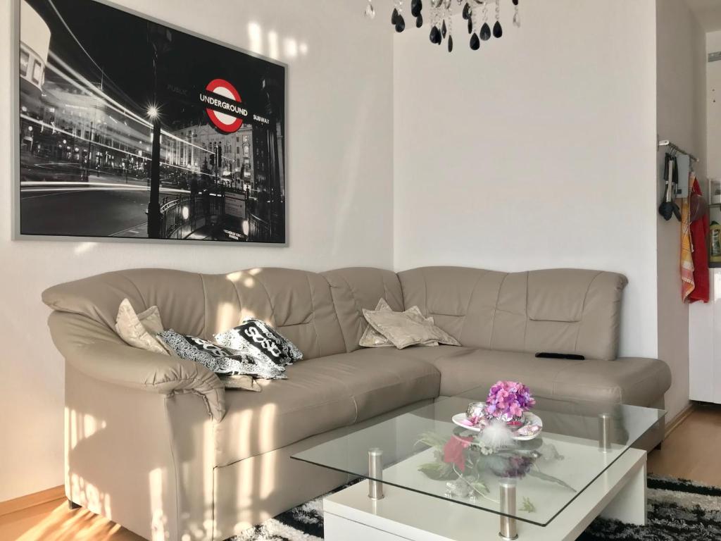 a living room with a couch and a glass table at Nice Private Apartments close to Hannover Fairgrounds in Hannover