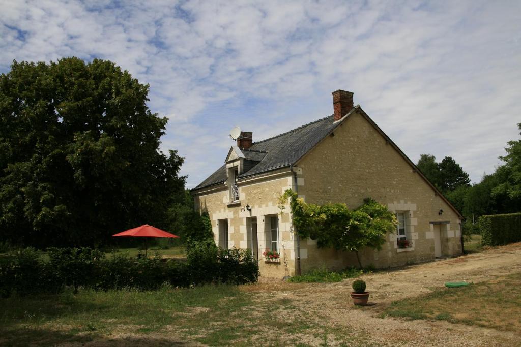 uma casa com um guarda-chuva vermelho em frente em Gîte du Moulin de Montrésor em Montrésor