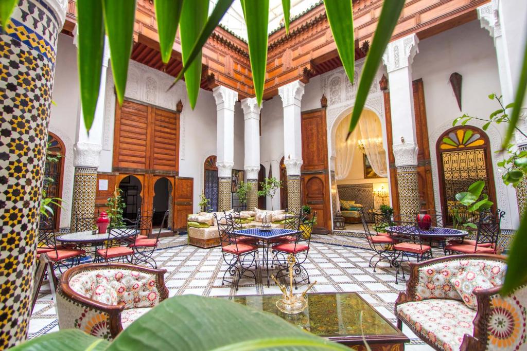 a courtyard with tables and chairs in a building at Riad Dar Skalli & SPA in Fez