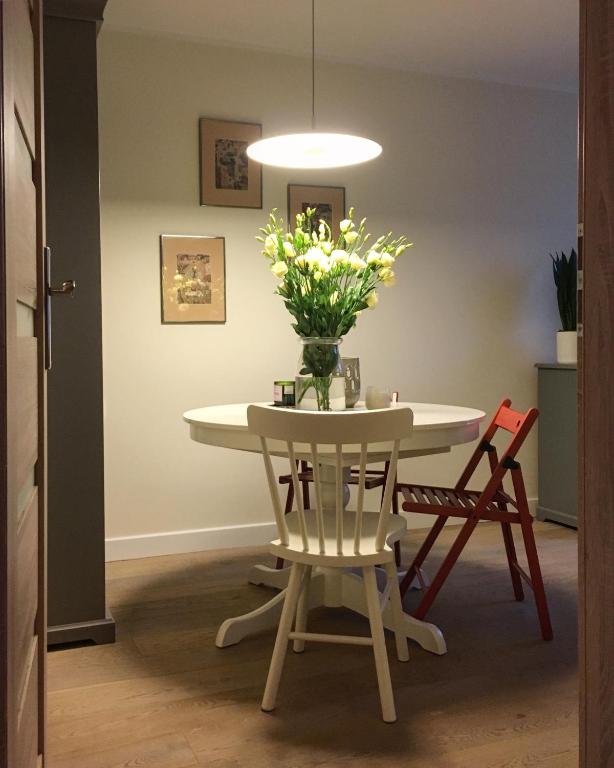 a dining room table with a vase of flowers on it at Oficyna Winiarza in Zabór
