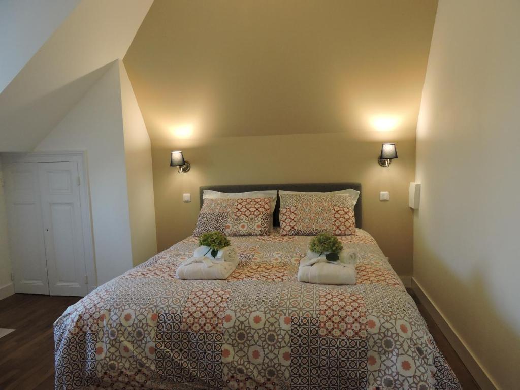 ein Schlafzimmer mit einem Bett mit zwei Pflanzen drauf in der Unterkunft Logis du Petit Dodo in Sainte-Jamme-sur-Sarthe